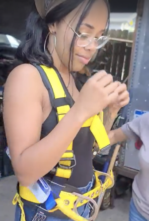 A digital steward at Grace in Action wearing a bright yellow safety harness