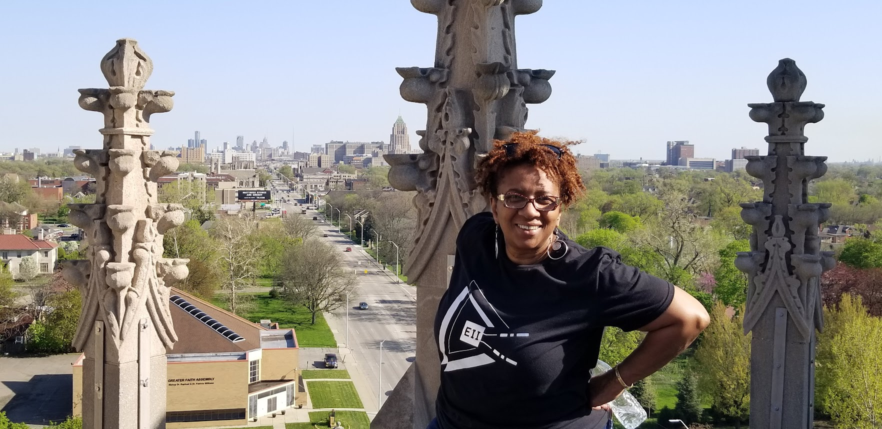 Monique Tate standing on a rooftop during an wireless Internet relay point installation, wearing an Equitable Internet Initiative t-shirt