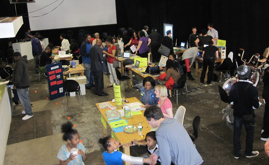 Overhead shot of a 2012 Discotech event at the Museum of Contemporary Art Detroit, with many people congregating around tables throughout the space